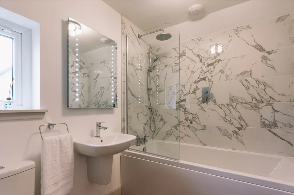 An Dòbhran upstairs en-suite bathroom with marble tiling, full-size bath with rain and hand held showers, White Company towels.