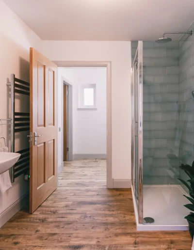 An Iolaire spacious downstairs bathroom with easy access large shower area with rain and hand-held showers and Highland Soap company toiletries